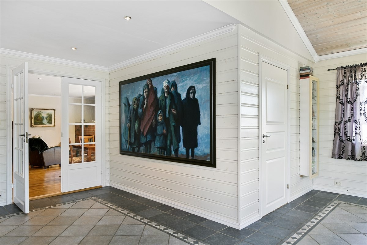 Rommet er innredet med fliser på gulv i ulike gråtoner, panel på veggene i kremhvitt og åpen garderobeløsning. Galleribilde