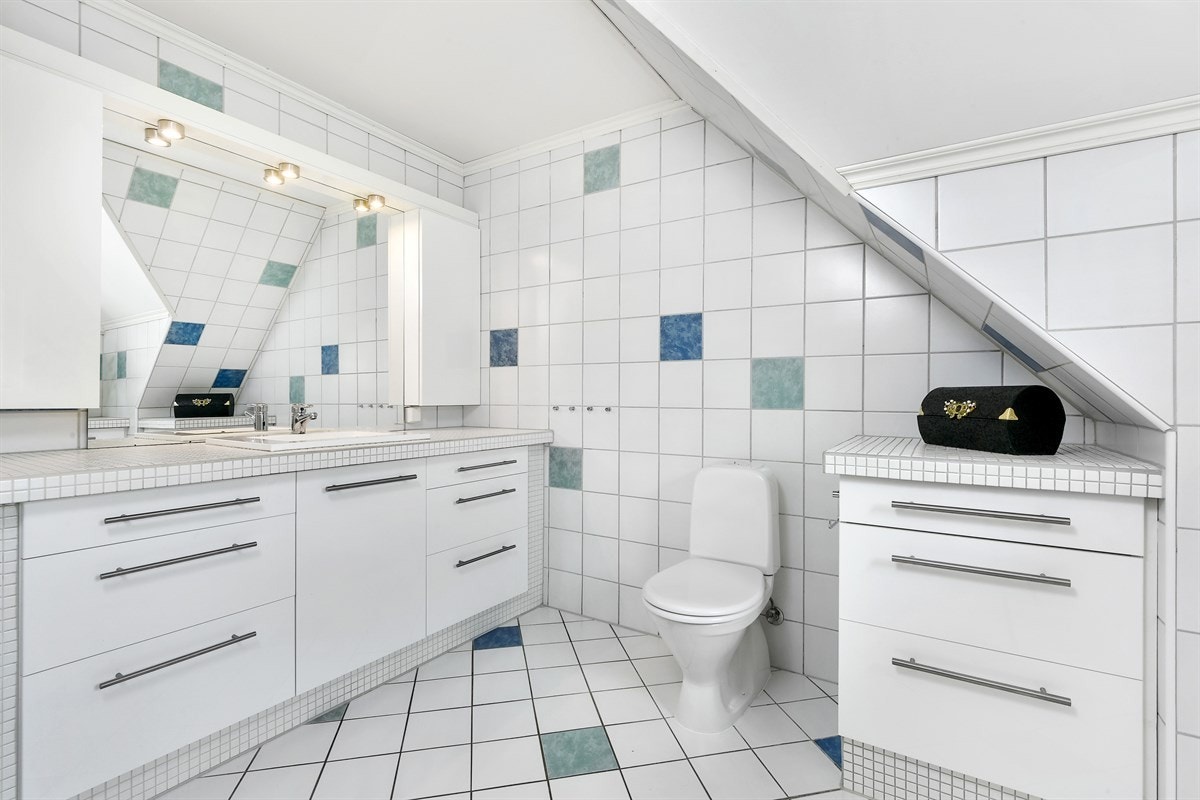 Badet i andre etasje har noe skråhimling og plassbygde løsninger med rikelig oppbevaringsplass i skuffer og skap. Galleribilde