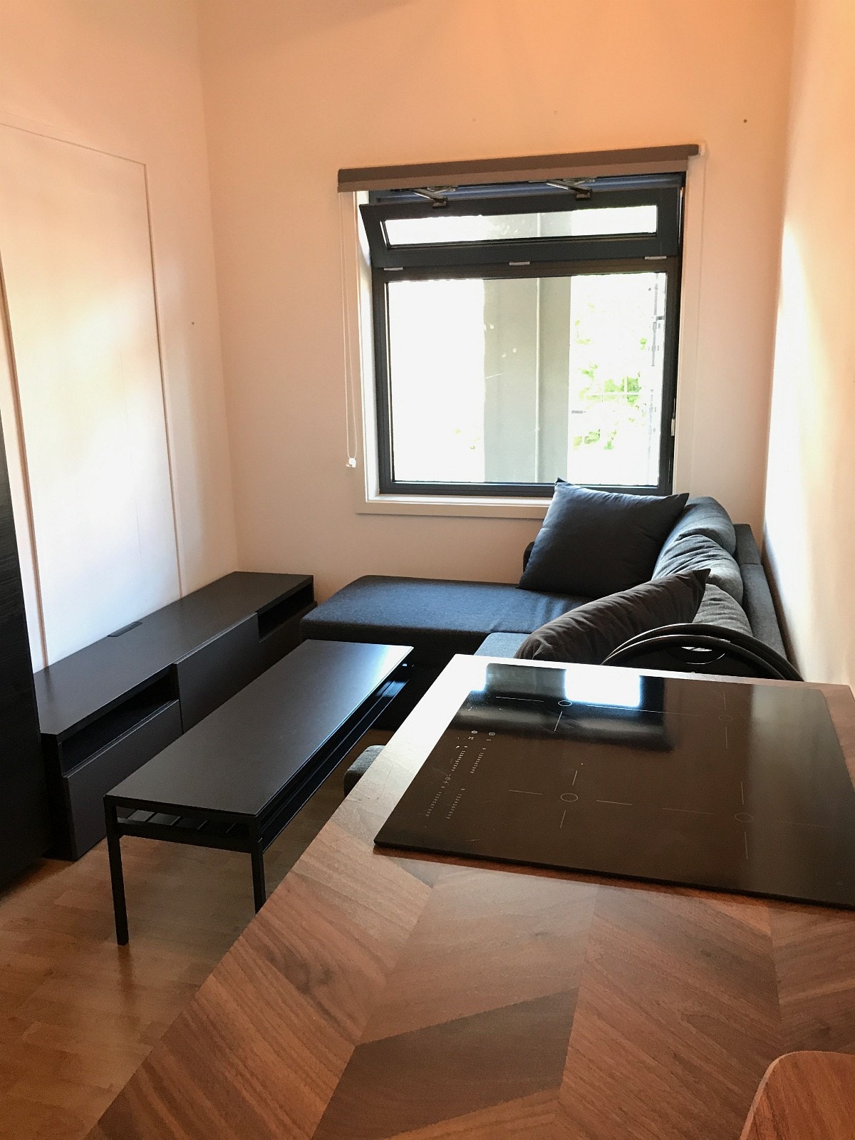 Stue med stilrene møbler, blant annet chaiselong sovesofa Galleribilde