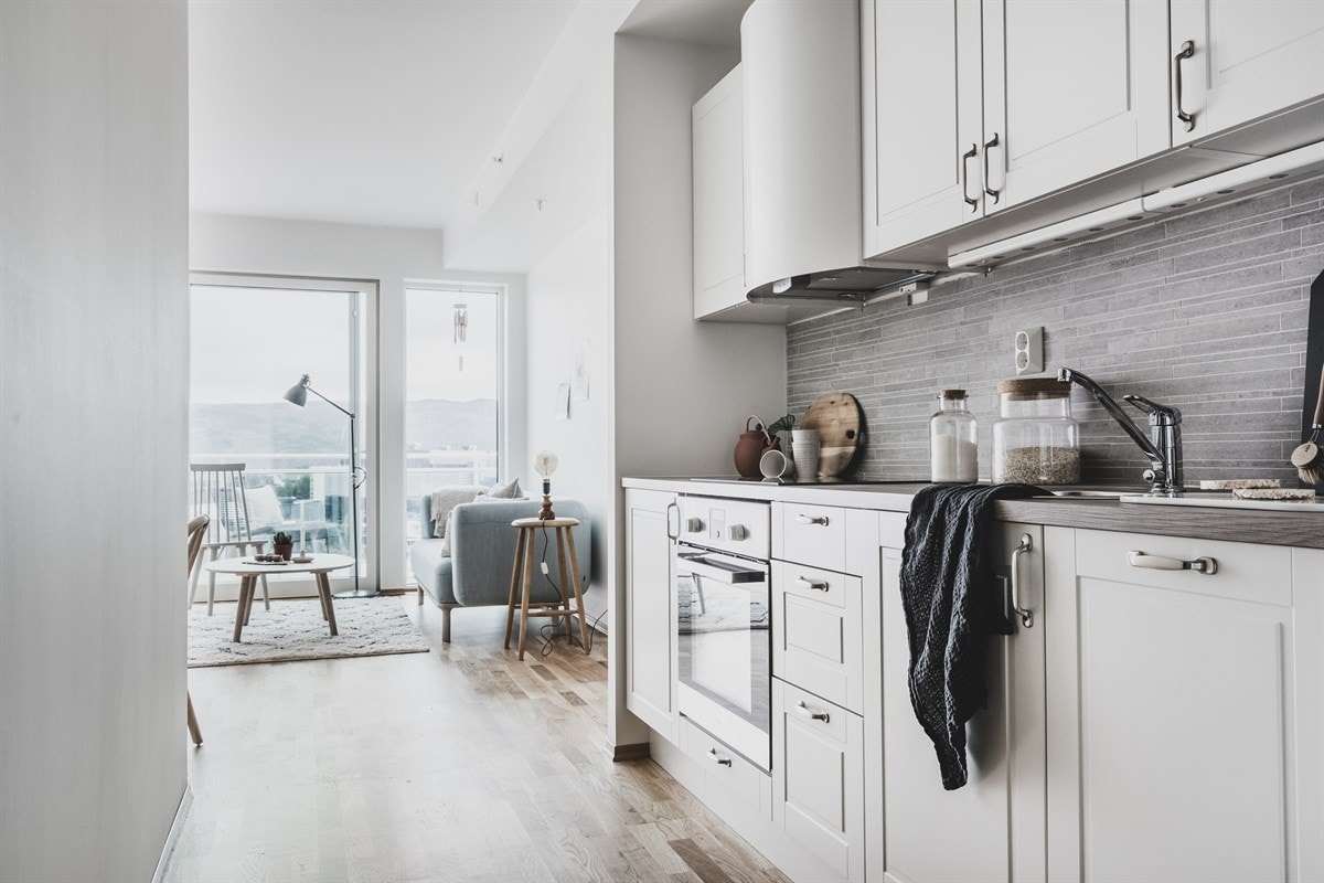 Kjøkkenet i leiligheten er svært delikat og skulle falle i smak hos de fleste! Det er profilerte, hvite fronter og lekre fliser over laminat benkeplate. Galleribilde
