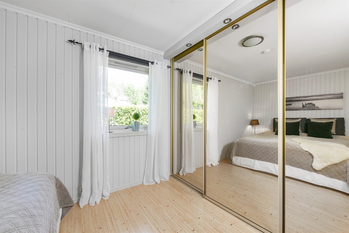 Soverom 1 med tilhørende skyvedørsgarderobe med glassdører. Galleribilde