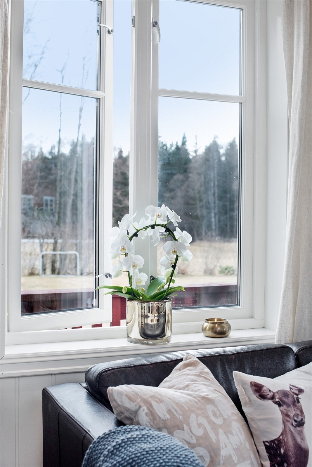 Stemningsbilde fra stue. Utsyn til skog og mark. Galleribilde