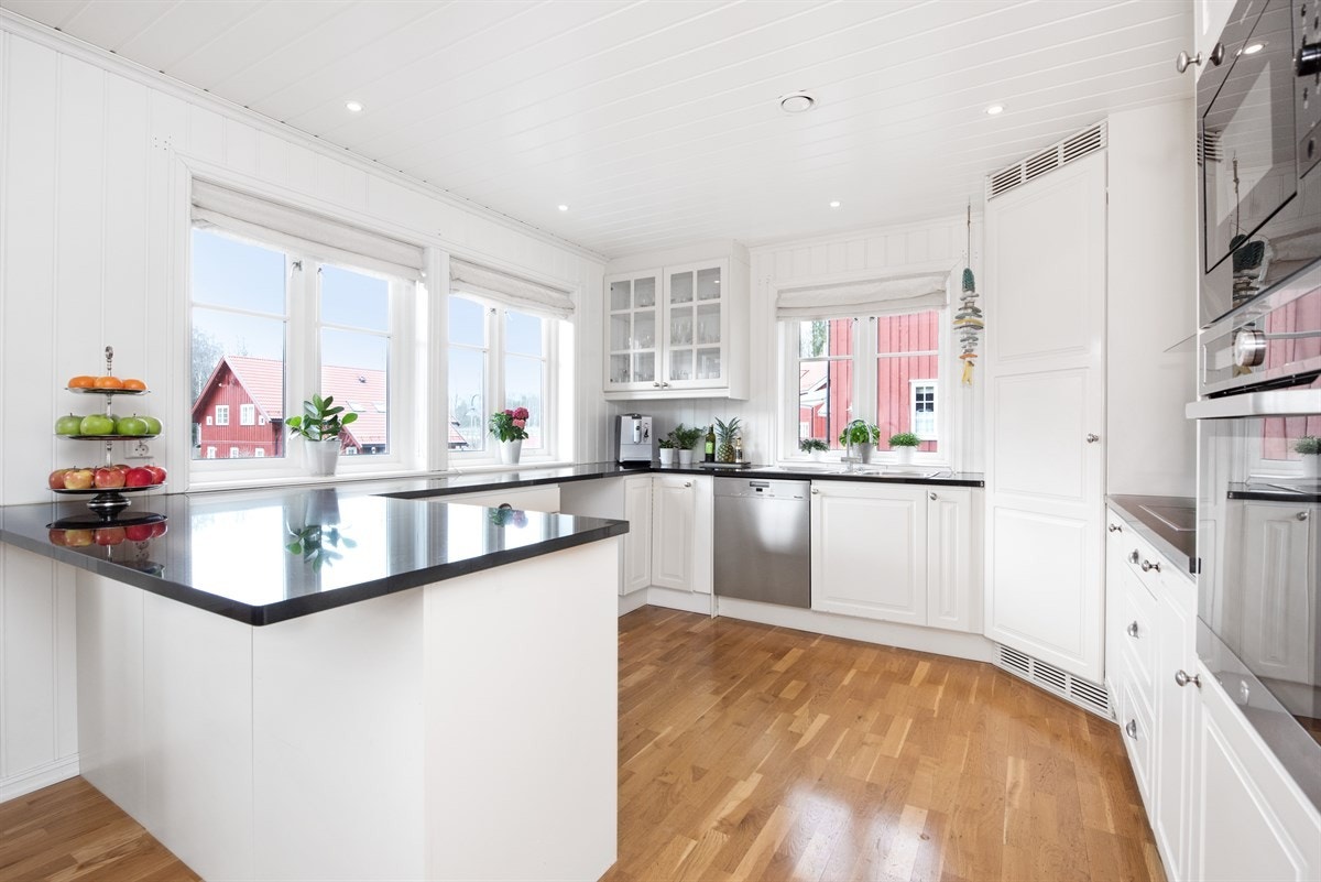 Kjøkken med integrerte hvitevarer og granitt benkeplater Galleribilde