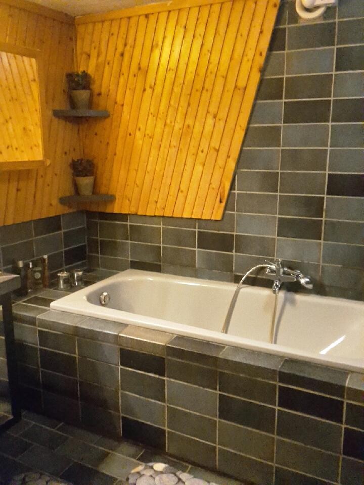 Tiltalende, flislagt bad med badekar & dusj, servant og toalett og god plass Galleribilde