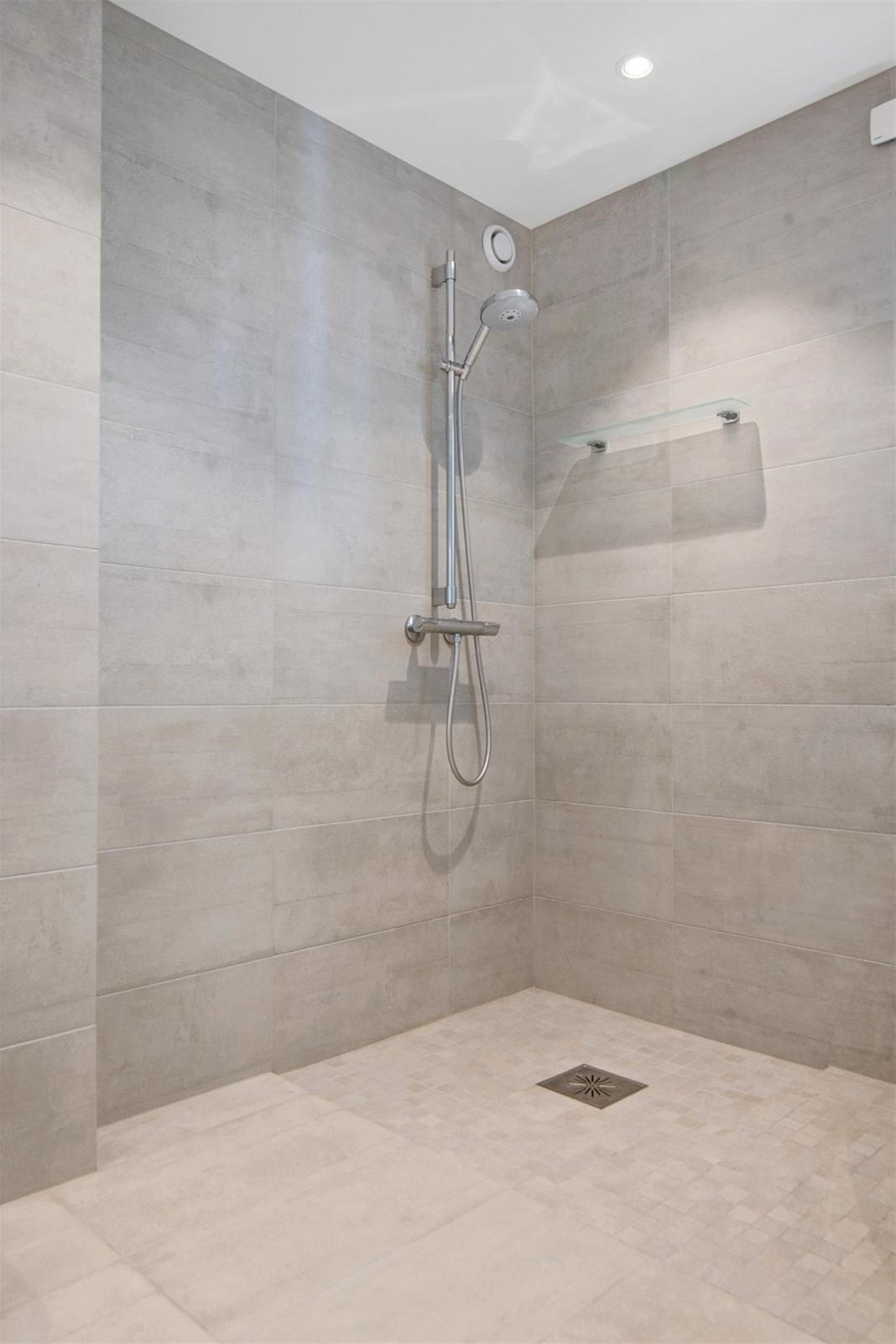 Stort flislagt dusjområde på badet til hovedsoverommet. Galleribilde