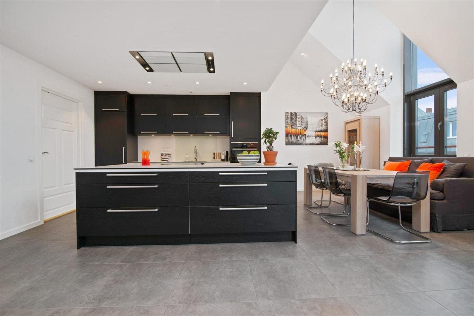 Et mørkt kjøkken som bryter opp de lyse overflatene. Meget påkostede hvitevarer. Stor plass til gedigen spisetue. Galleribilde