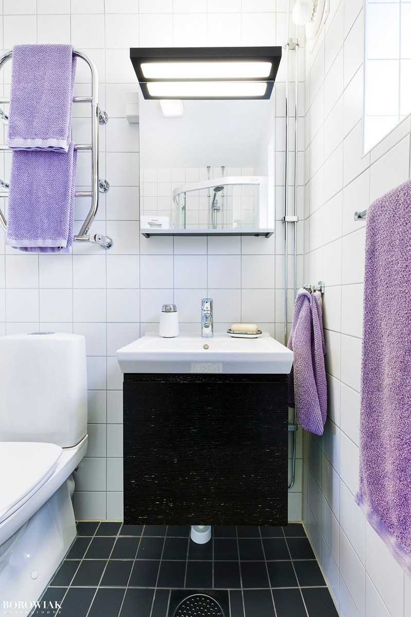 Et romslig bad med dussjone med skyvedører, praktisk nisje med opplegg for vaskemaskin og tørketrommel, frittstående toalett og servant med underskap med plass for oppbevaring. Galleribilde