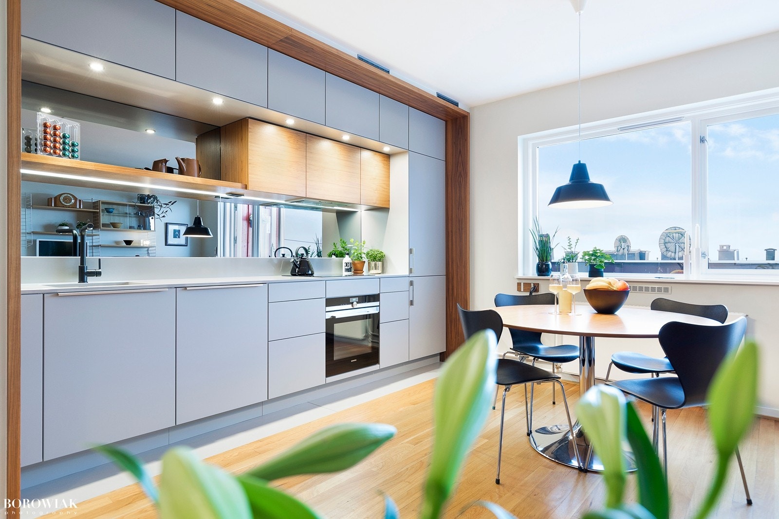 Rålekkert prisbelønnet Multiform kjøkken fra 2015 i delikat utførelse med grepsfrie slette grå fronter fra Multiform med folierte valnøtt detaljer fra Wiesewood. Galleribilde