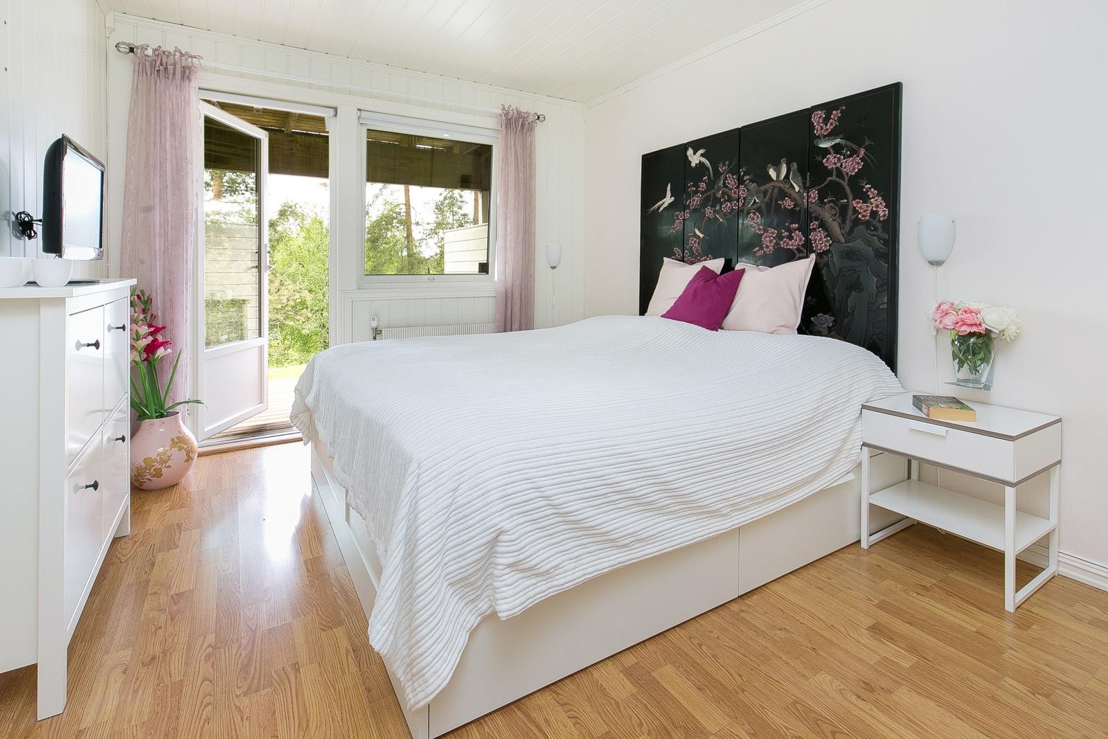 Lyst og koselig hovedsoverom i moderne fargevalg. Opplegg for Tv. Utgang til koselige terrassert hage i grønne omgivelser. Galleribilde