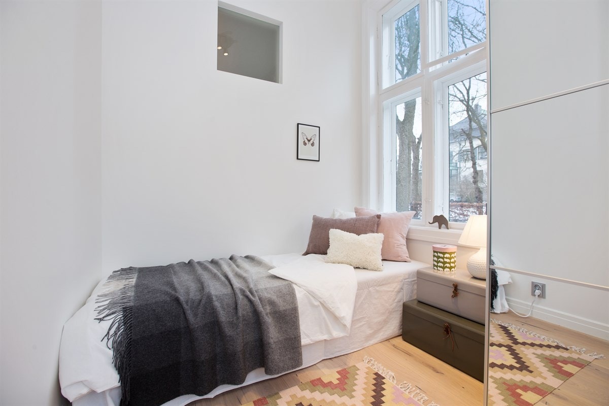 Soverom 2 har stort vindu, parkett på gulv og tilhørende garderobeløsning Galleribilde