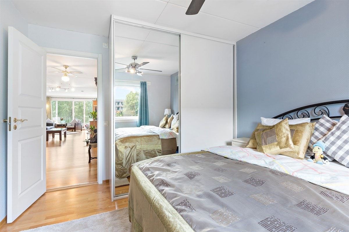 Masterbedroom med skapinnredning og takhøy, stor syvedørsgarderobe Galleribilde