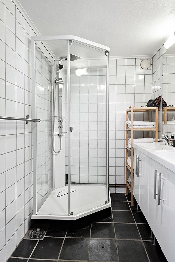 Romslig eldre bad. Badet preges av nøytrale og delikate materialvalg med hvite fliser på vegg og sorte gulvfliser. Galleribilde