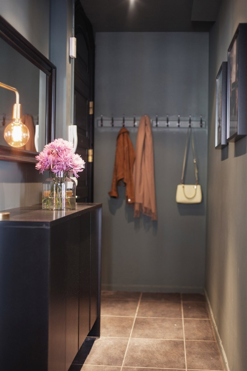 Både overflater og tak en malt i en mørk og behagelig tone og alle detaljer, samt ytterdøren går i sort Galleribilde