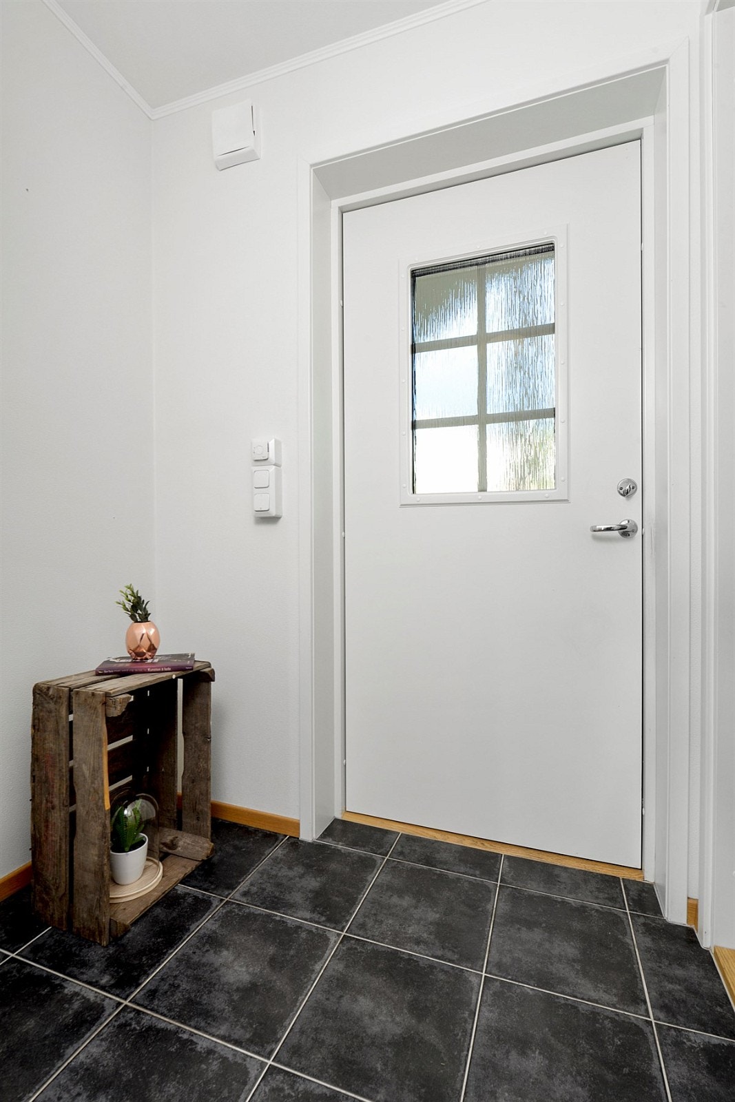 Entreen gir et godt førsteinntrykk av leiligheten og er praktisk innredet med bl.a. mørke fliser på gulv, gulvvarme og stor åpen garderobeløsning for enkelt oppheng av yttertøy. Galleribilde