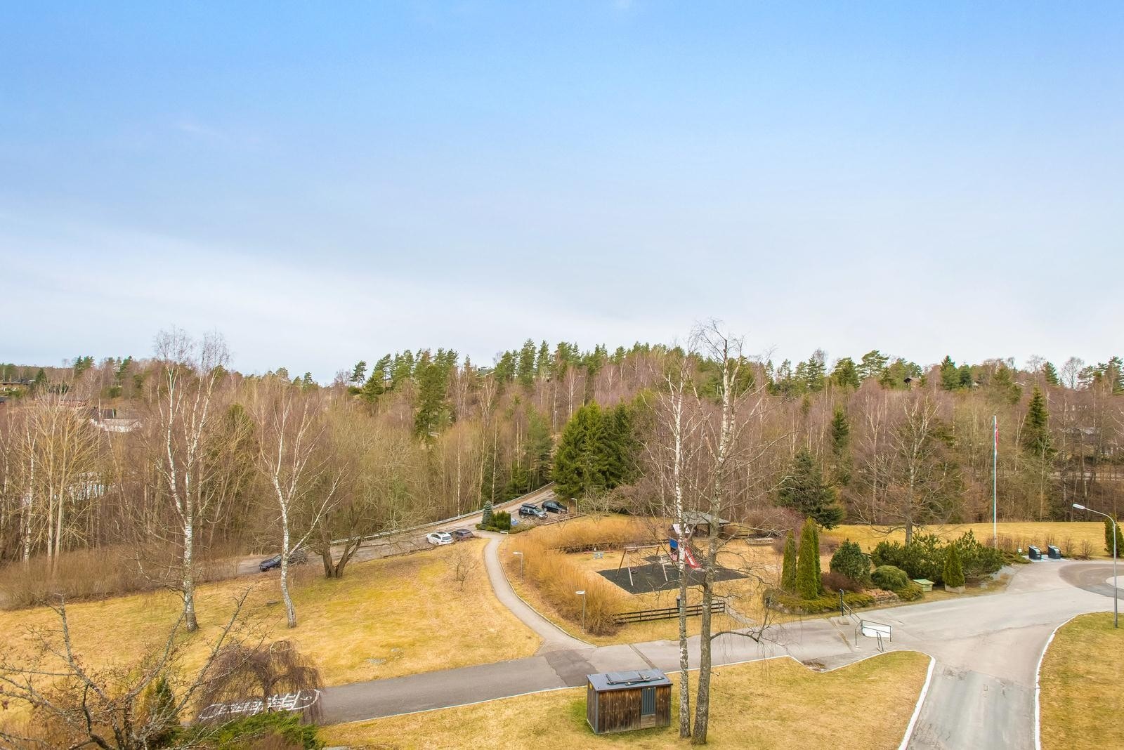 Slalåmveien 5 G - Utsyn fra balkong mot sameiets fellesarealer med sittegrupper og lekeområder Galleribilde