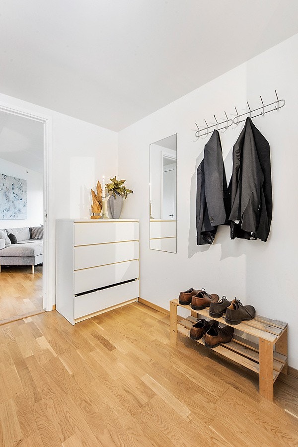 Innbydende og romslig gang. Her har du rikelig med plass for garderobeskap. 3-stav parkett på gulv og hvitmalte flater på vegg som går igjen i stuen og kjøkkenet. Galleribilde