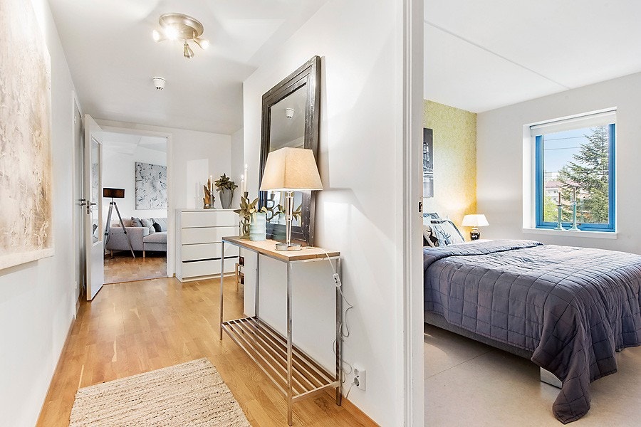 Innbydende og romslig gang. Her har du rikelig med plass for garderobeskap. 3-stav parkett på gulv og hvitmalte flater på vegg som går igjen i stuen og kjøkkenet. Galleribilde