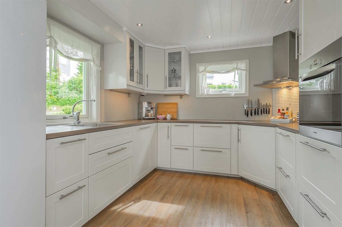 Lekkert kjøkken med integrerte hvitevarer og induksjonstopp Galleribilde