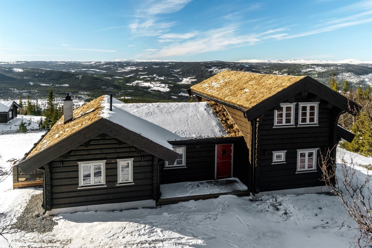 Inngangsparti med terrasse og bod på høyre side av hytta Galleribilde