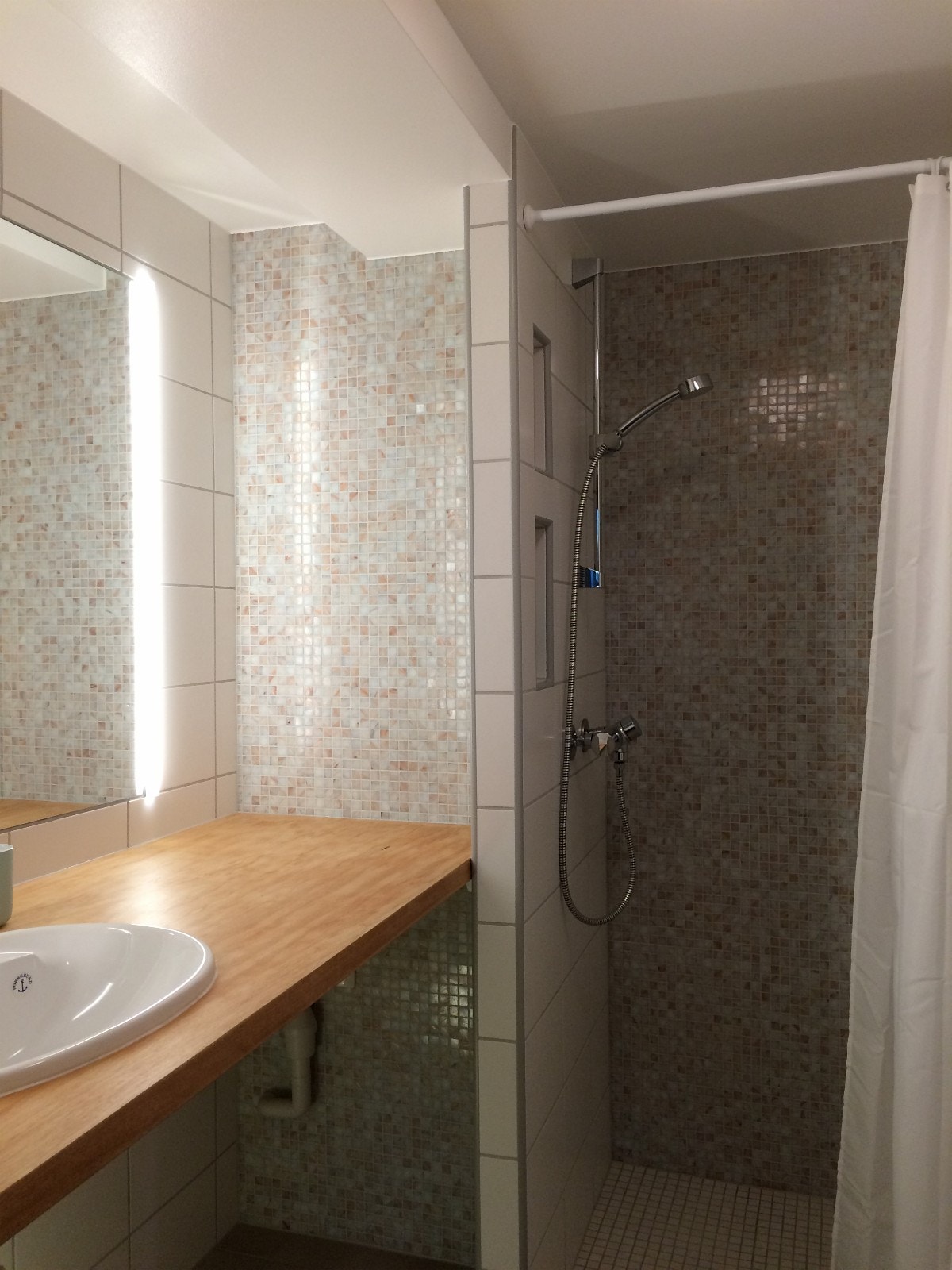 Flislagt bad med varmekabler, dusjnisje og vaskemaskin. Galleribilde