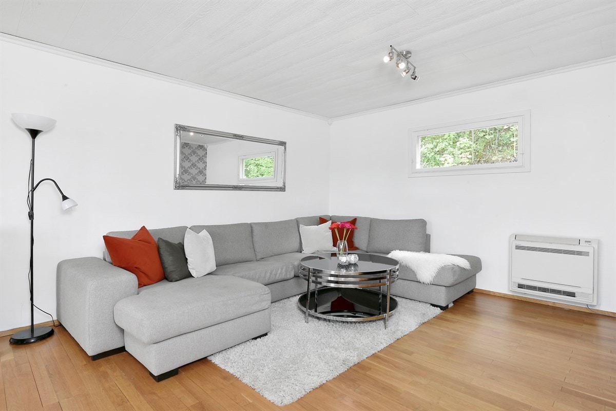 Stuen har parkett på gulv og hvitmalt tapet på vegg, pent alternert med en lys mønstertapet på fondvegg. Galleribilde