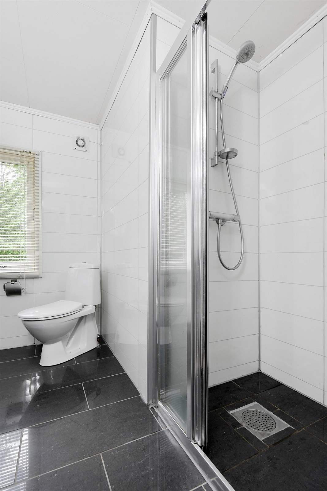 Badet har frittstående toalett, dusjnisje med skyvedør, samt opplegg for vaskemaskin og tørketrommel. Galleribilde