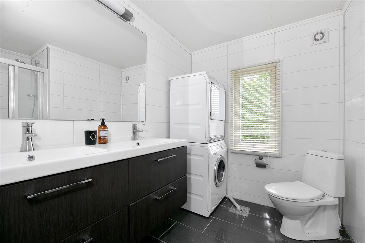 Badet er modernisert av nåværende eier i nyere tid. Rommet har grå, polerte fliser på gulv og hvite flisplater på vegg. Galleribilde