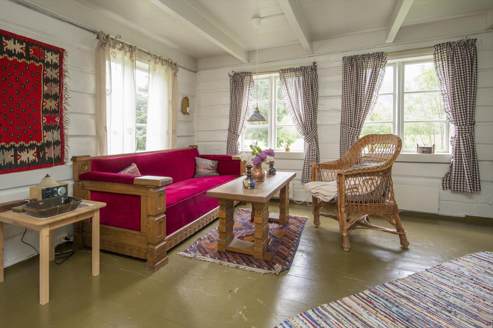 Stuen har et koselig hyttepreg med tømmervegger og tregulv Galleribilde