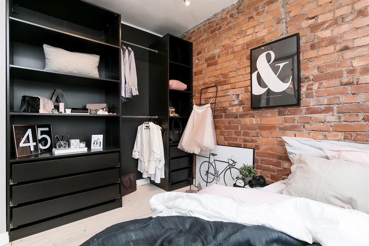 På soverommet har man fått frem teglsteinen som gir en rustikk følelse samt et flott plassbygd skap med god oppbevaring Galleribilde