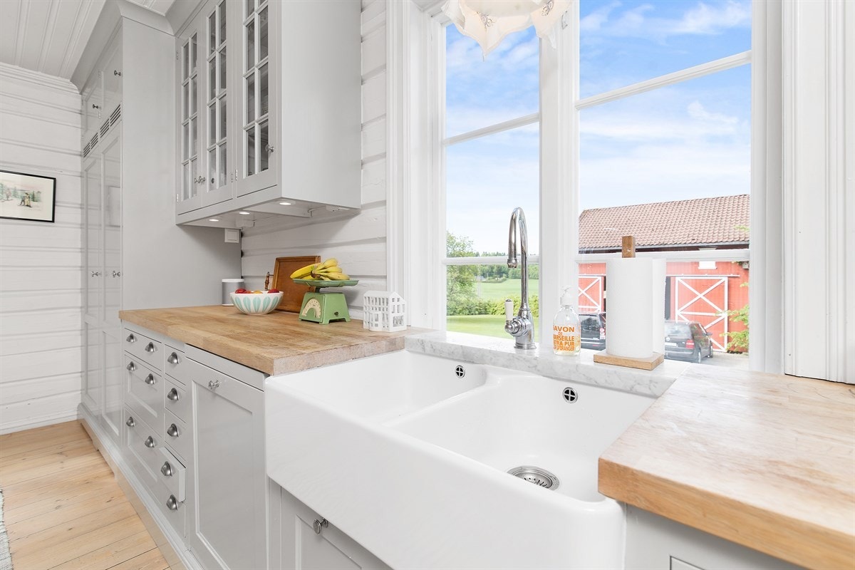 Fint utsyn til tunet fra kjøkkenet. Vaskekummer i porselen. Galleribilde