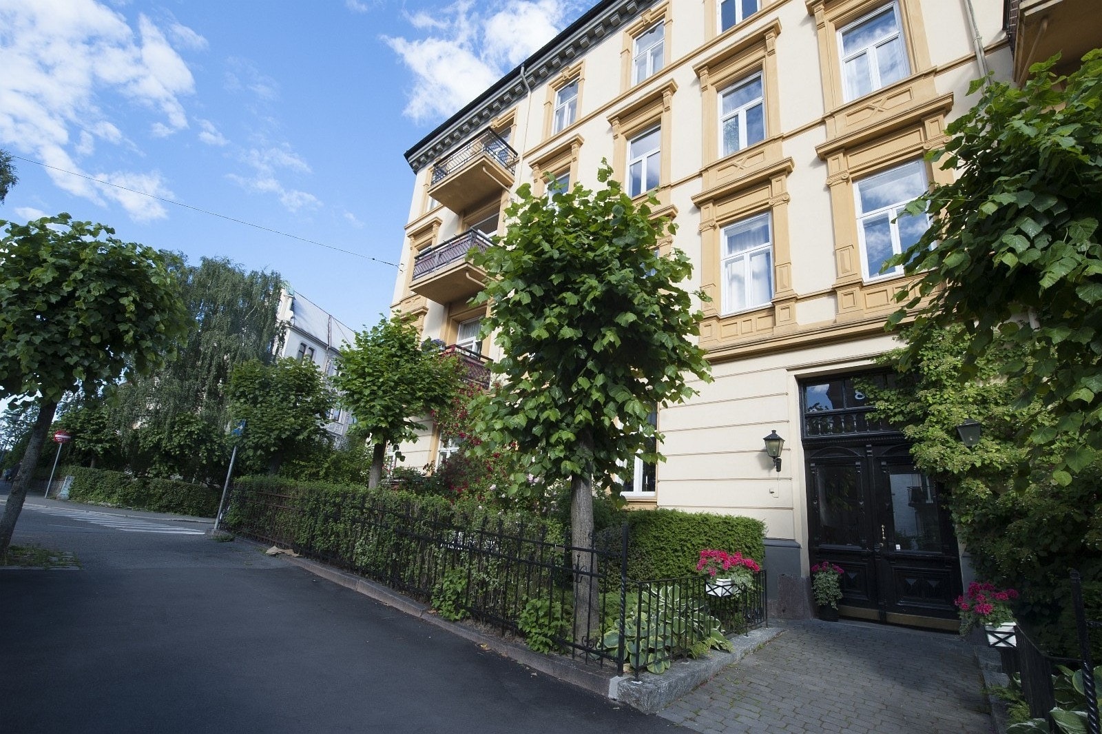 Velholdt fasade med frodig forhage. Galleribilde