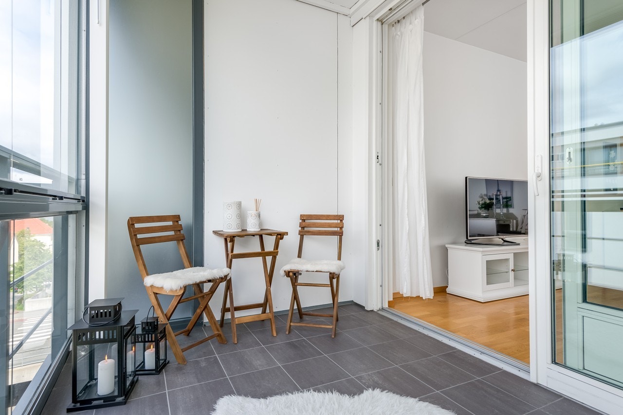 Fra stuen kan du spasere direkte ut til den store og utvidet balkongen med lun atmosfære bak glassrekkverket. På varme sommerdager funkerer balkogen som en utvidelse av stuen Galleribilde