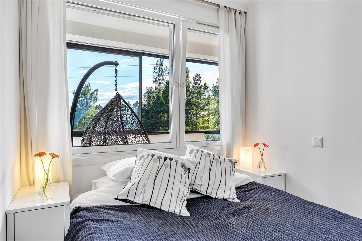 Store vindusflater på soverom som vender ut mot balkong Galleribilde