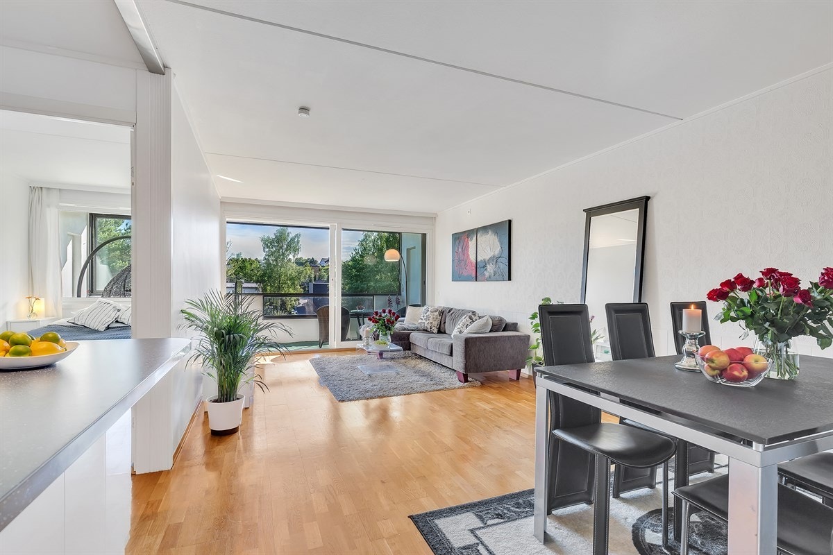 Lys og romslig stue som ligger i en delvis åpen stue/kjøkken løsning Galleribilde