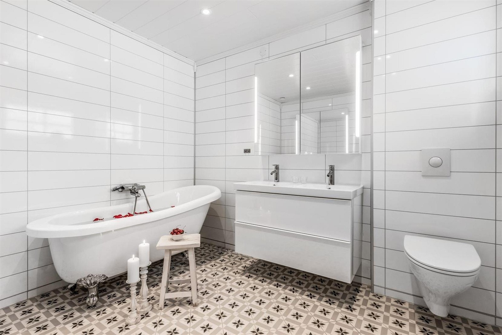 Dobbelvask med speilglass i overskap. Veggmontert wc med trykkbetjening. Galleribilde