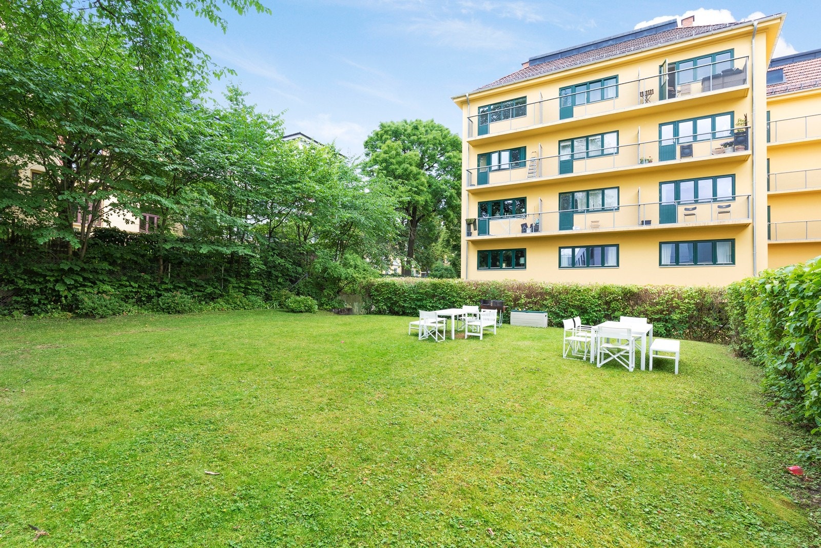 Aksjelaget har en felles bakgård som er flott opparbeidet med frodig grøntarealer med sittegrupper til disposisjon for beboerne. Galleribilde