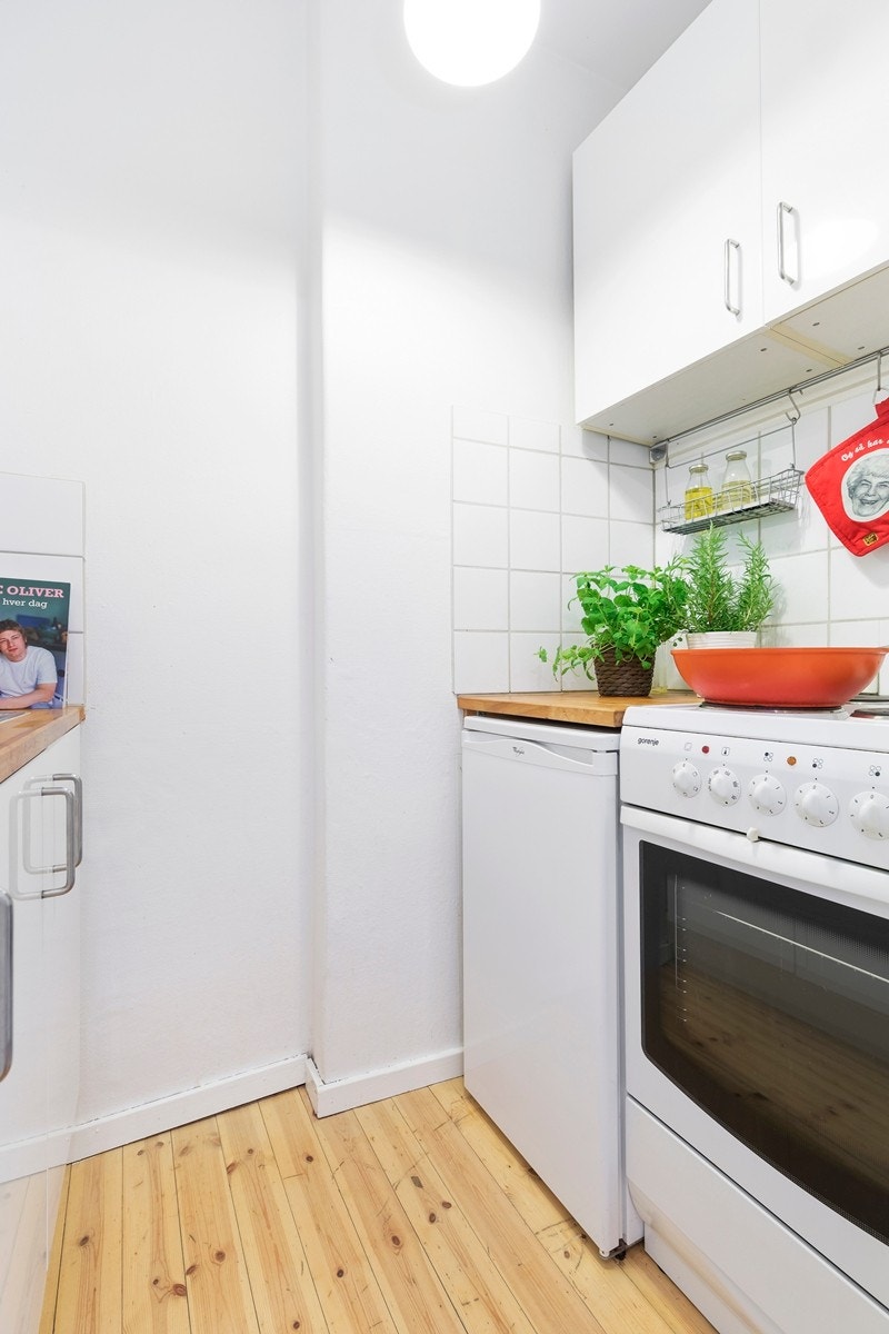 Kjøkkenet er utstyrt med frittstående komfyr med koketopp, samt frittstående kjøleskap. Fliser mellom benk og overskap. Heltre benkeplate. Galleribilde