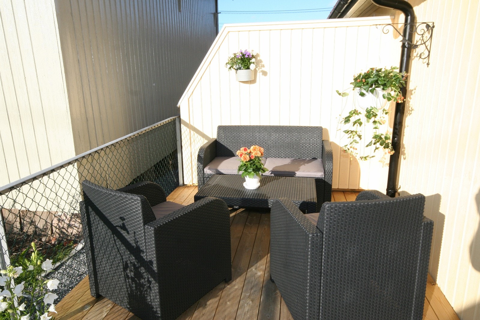 Terrassen er møblert med toseter bord og to stoler Galleribilde