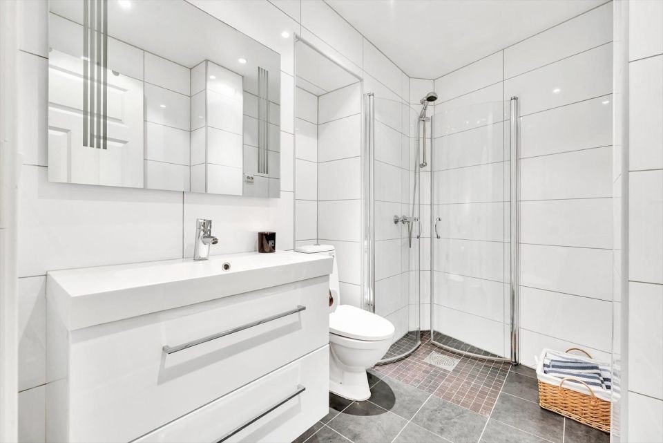 Badet har lyse fliser og innfellbar dusj, noe som øker romfølelse. Nytt toalett satt inn 2024. Galleribilde