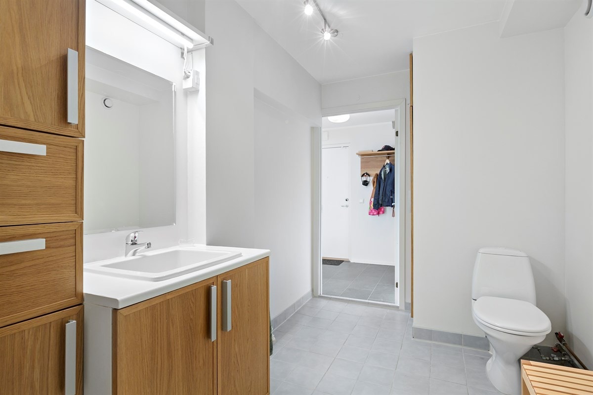 Romslig bad med wc, dusjkabinett, servant med ettgreps blandebatteri i innredning. Galleribilde