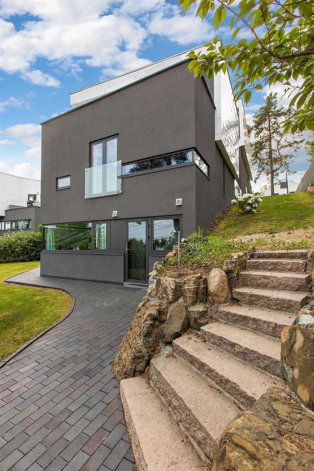 Det går trapp fra hagen opp til begge sider av boligen Galleribilde