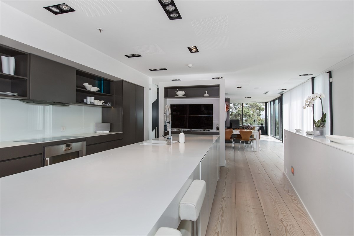 Rette og lange linjer gjennom 2. etg. fra kjøkkenet og ut gjennom spisestuen til stuen Galleribilde