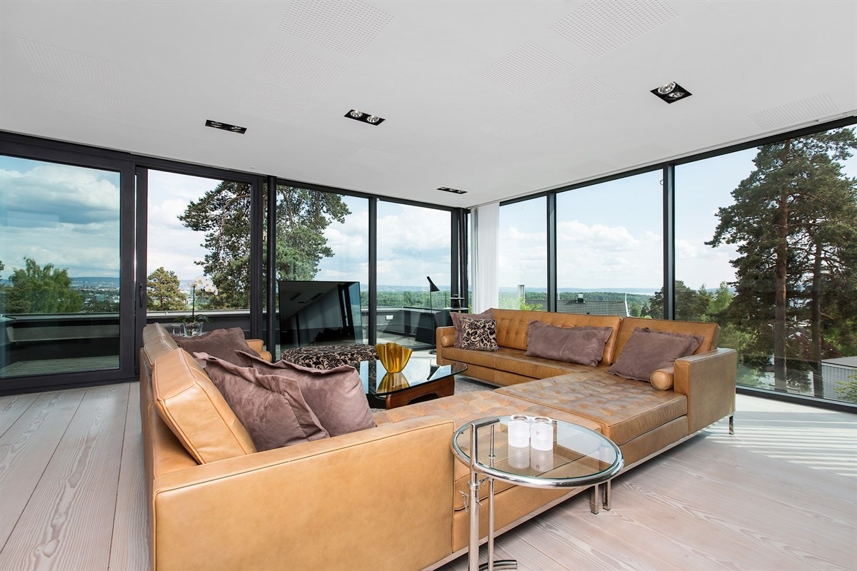 Stue med vinduer fra gulv til tak på alle tre sider og panorama Galleribilde