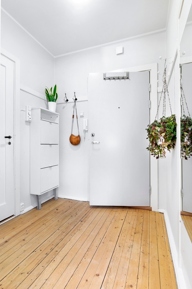 Romslig entrè med enkel adkomst fra bakkeplan. Sjarmerende originalt tregulv som også går igjen på soverom. God plass for garderobe for sko og yttertøy. Galleribilde