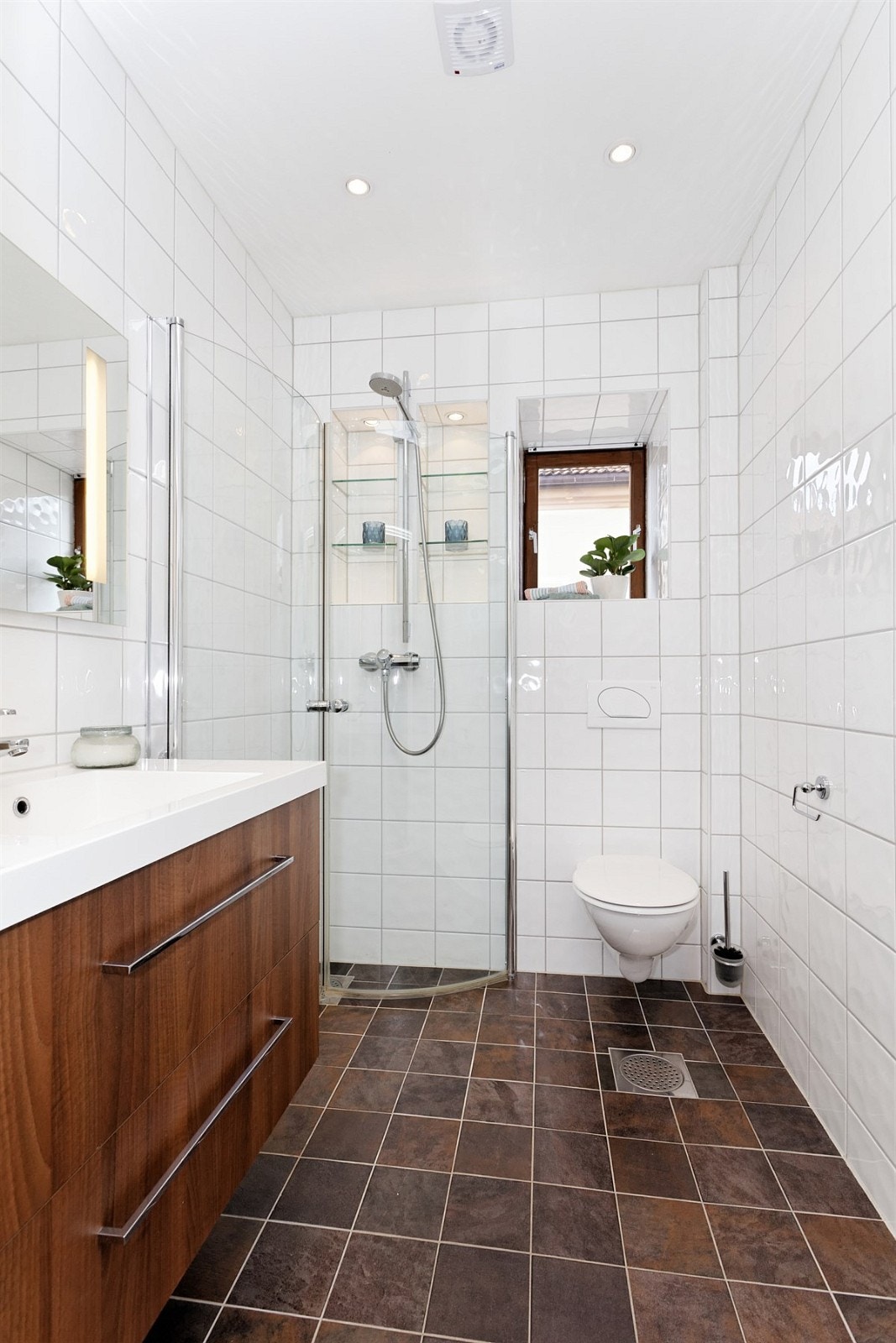 Rommet har fliser på gulv og vegger, gulvvarme og et vegghengt toalett. Galleribilde