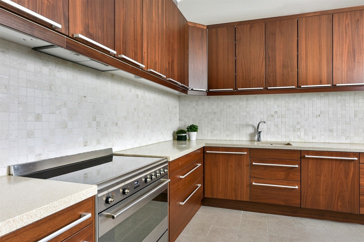 Innredningen har nøttefargede, glatte fronter og benkeplate i lys kompositt med integrert vaskekum. Galleribilde