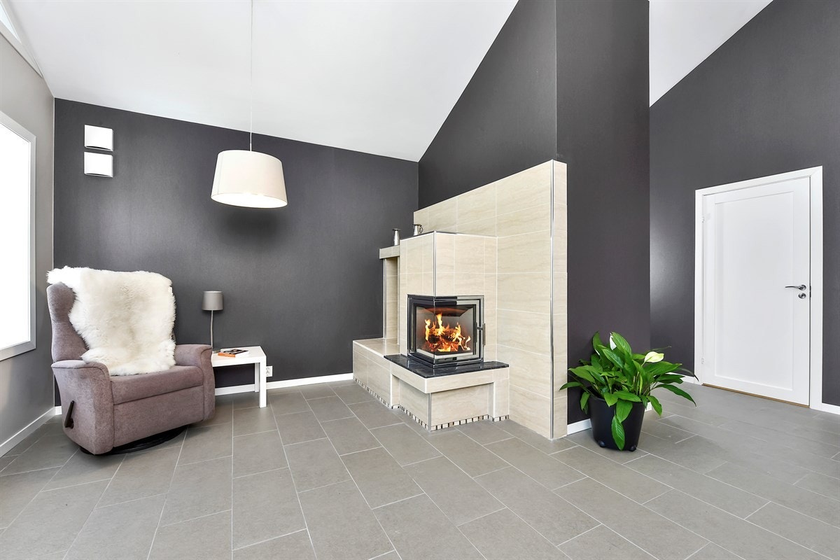 Stuen har lyse fliser på gulv, hvitmalt himling og veggflater holdt i pene grånyanser. Galleribilde