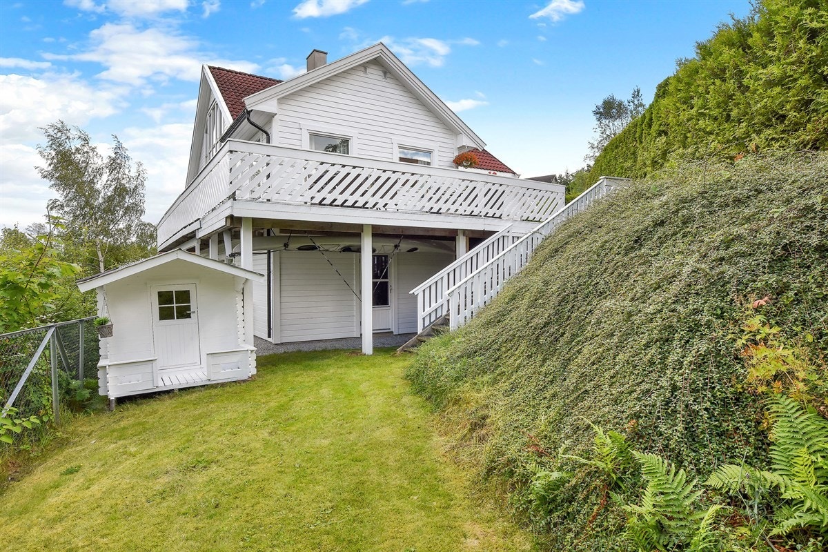 Fra terrassen går det trapp ned til en fin hage, som innehar et inngjerdet plenareal med diverse beplantning. Galleribilde