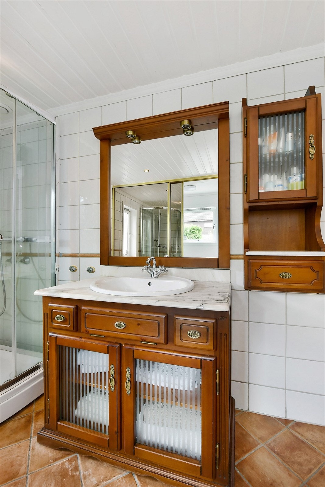 Badet innehar downlights i himling, brune fliser på gulv og lyse fliser på vegg. Galleribilde