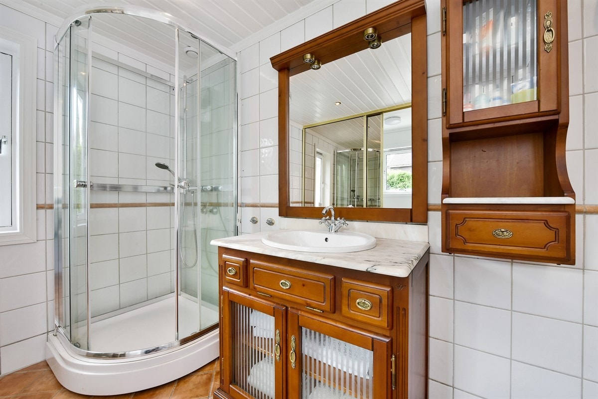 Boligen inneholder et romslig og pent bad, hvor det er skyvedører til et separat vaskerom. Galleribilde